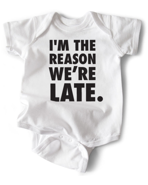 A white cotton funny onesie made by wrybaby with 'I'm the Reason We're Late' printed on the front in a nice design