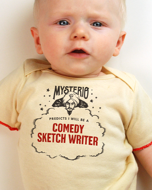 A baby wearing wrybaby's funny fortune teller t-shirt that says 'Mysterio Predicts I will be a Comedy Sketch Writer'