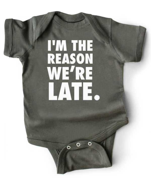 A gray cotton funny onesie made by wrybaby with 'I'm the Reason We're Late'' printed on the front in a nice design