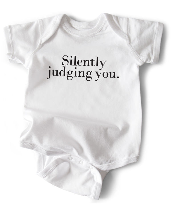 A white cotton funny onesie made by wrybaby with 'Silently Judging You' printed on the front in a nice design
